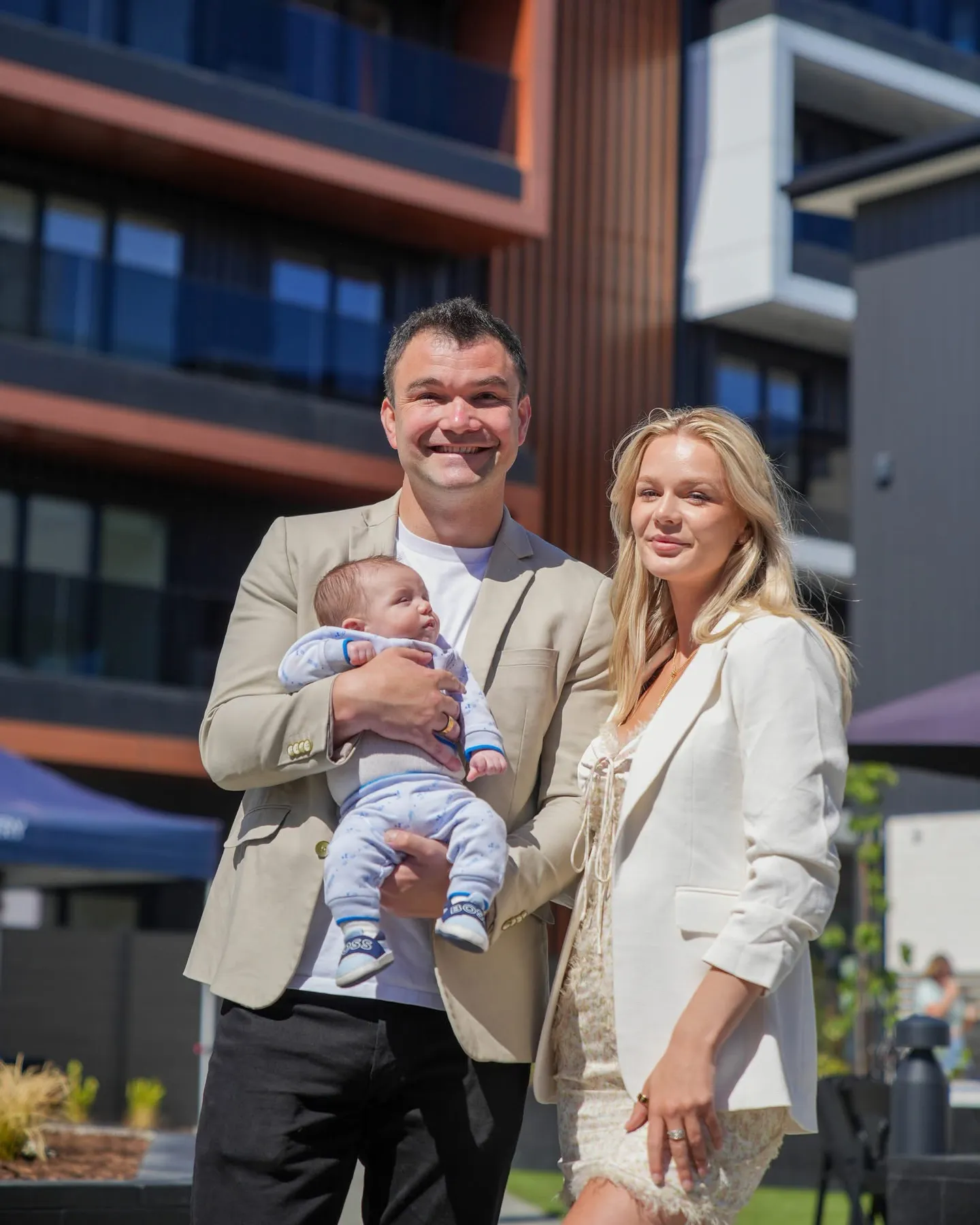 Matthew Horncastle and Hannah Bungay holding Alexander outside a completed development